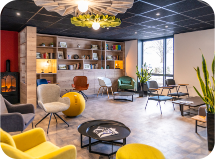 Salon cosy et décoré à l'hôtel Ibis de Pontarlier, offrant un espace de détente chaleureux